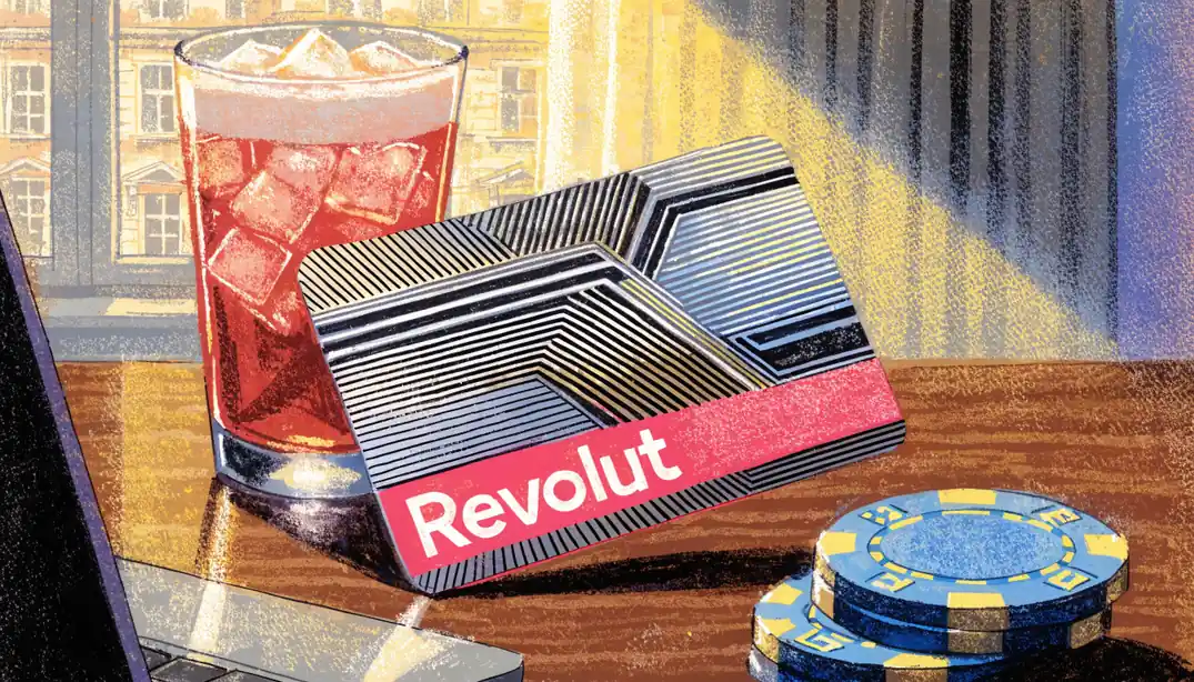 Revolut card held above a desk with casino chips nearby